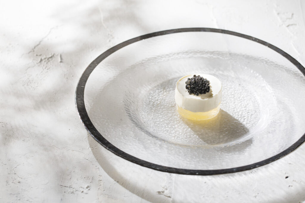 贅沢なキャビアの輝き。透明感あふれる器が引き立てる、至高のプロローグ。