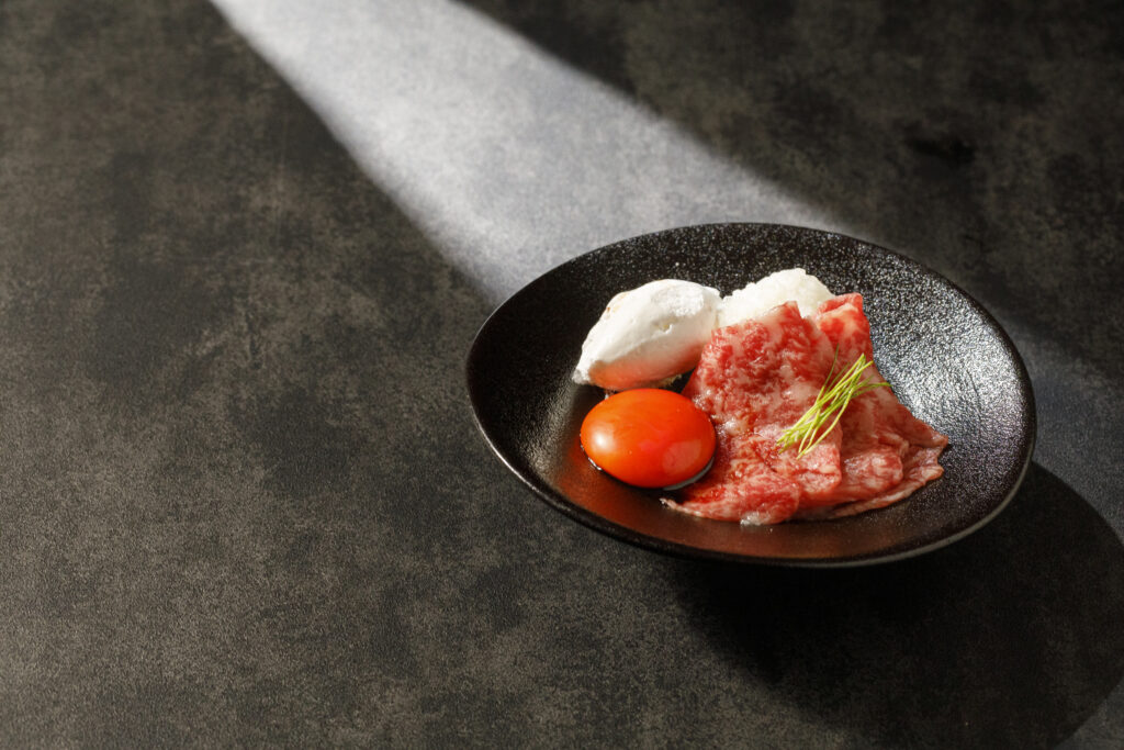 最高級黒毛和牛の至福。濃厚な卵黄が絡み合う、とろけるような口福の瞬間。