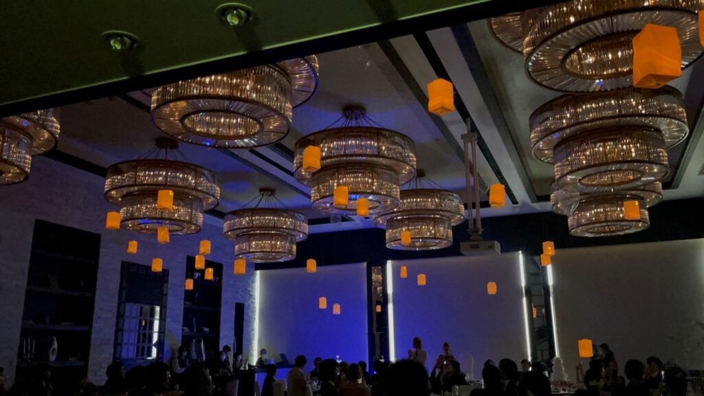 名古屋市の結婚式場ビアンカーラヒルサイドテラス。シャンデリア輝く披露宴会場で、新郎新婦とゲストがランタンを飛ばす幻想的なスカイランタンの演出。