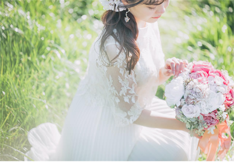 名古屋市結婚式場ビアンカーラヒルサイドテラス。ブーケを持った新婦が下を向きながら写真に写っている。ロケーション撮影の様子。