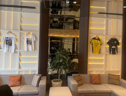 名古屋市の結婚式場ビアンカーラヒルサイドテラスの結婚式会場の壁に飾られたおふたりゆかりのスポーツユニフォームとソファ席、趣味を取り入れたウェルカム装飾