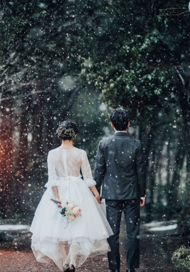 雪が降る中でのロマンチックなウェディングフォト。