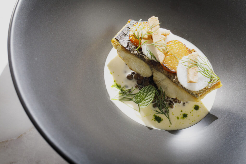 名古屋市の結婚式場ビアンカーラヒルサイドテラスの婚礼料理。皮目をパリッと焼き上げた真鯛のポワレに、ハーブが香る濃厚な白ワインソースを添えた逸品。