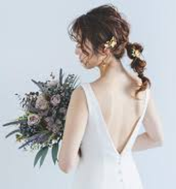 【ビアンカーラヒルサイドテラス】の光り輝くクリスタルチャペルにて、気品溢れるティアラを身に纏った花嫁様。名古屋市にある市の式場で叶える王道のプリンセススタイルを詳細に描写しており、名古屋市内での結婚式らしい、光に包まれた神聖な挙式シーンを表現しています。